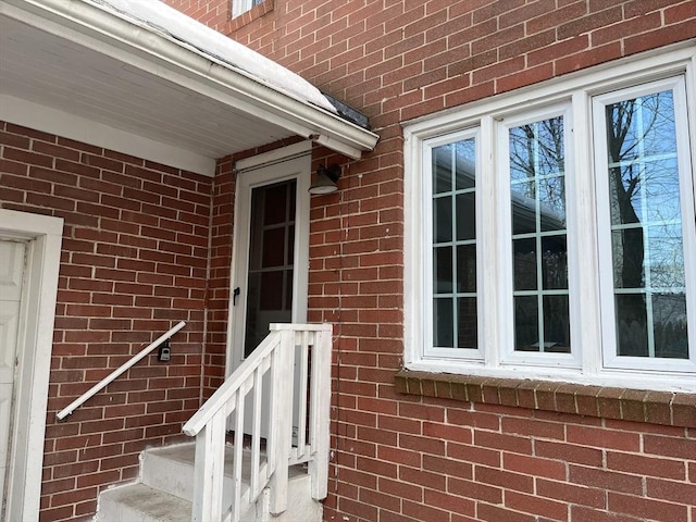 doorway to property featuring brick siding