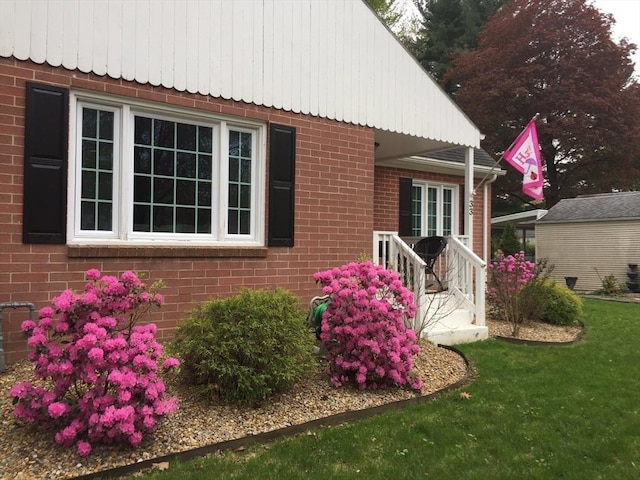 exterior space with brick siding and a lawn