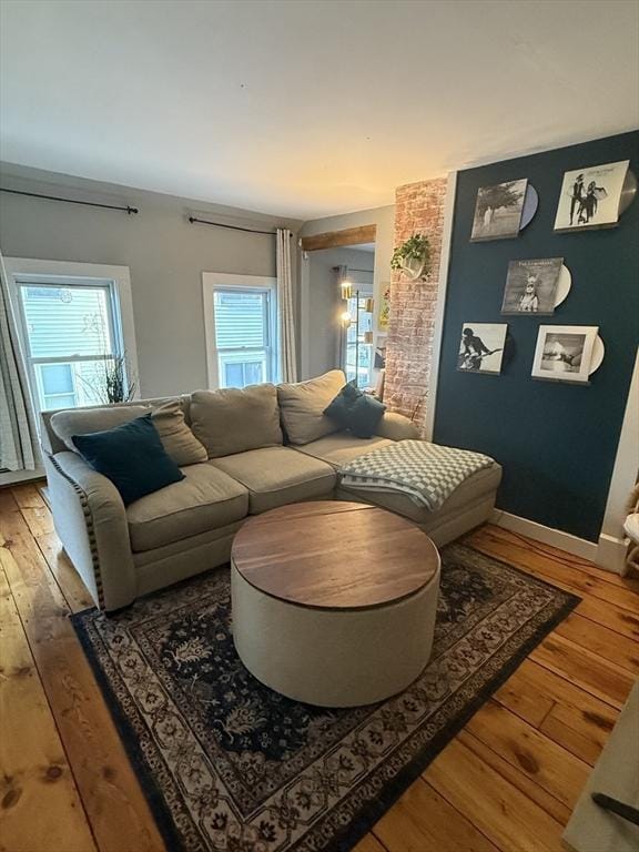 living room with light wood-type flooring, plenty of natural light, and baseboards