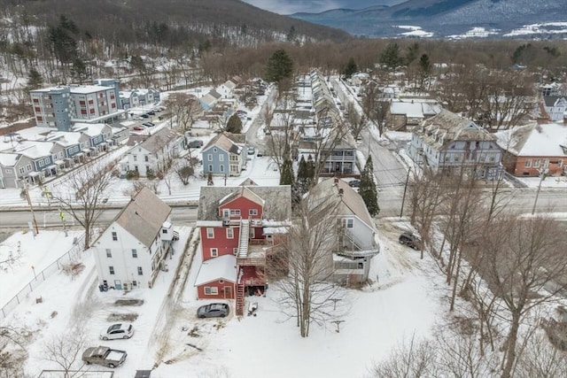 snowy aerial view featuring a residential view and a mountain view