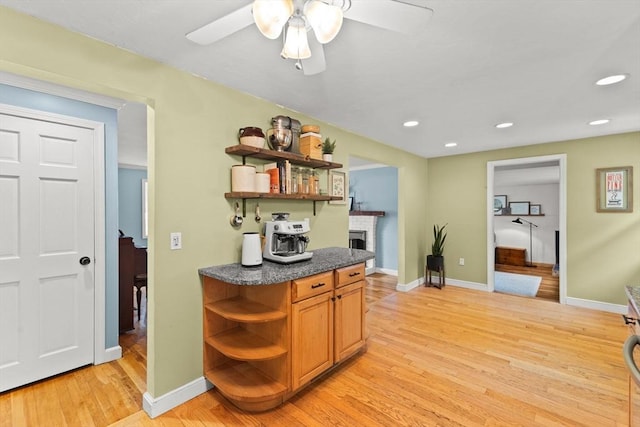 2025 S St, Bridgewater, MA 02324 - kitchen with open shelves, light wood-style flooring, dark countertops, a fireplace, and recessed lighting