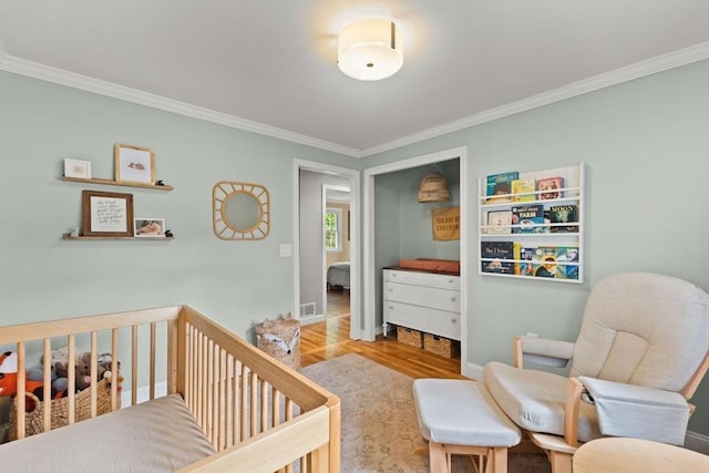 2025 S St, Bridgewater, MA 02324 - bedroom with ornamental molding, wood finished floors, a crib, and baseboards