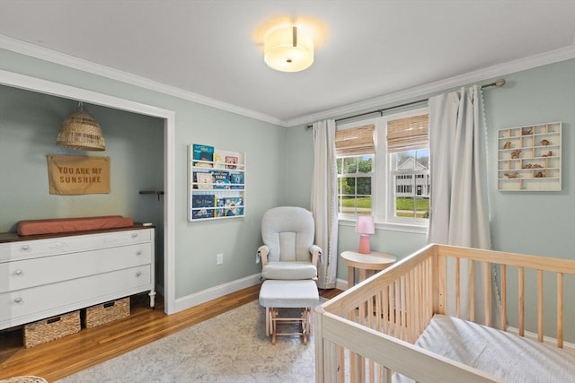2025 S St, Bridgewater, MA 02324 - bedroom with wood finished floors, ornamental molding, a crib, and baseboards