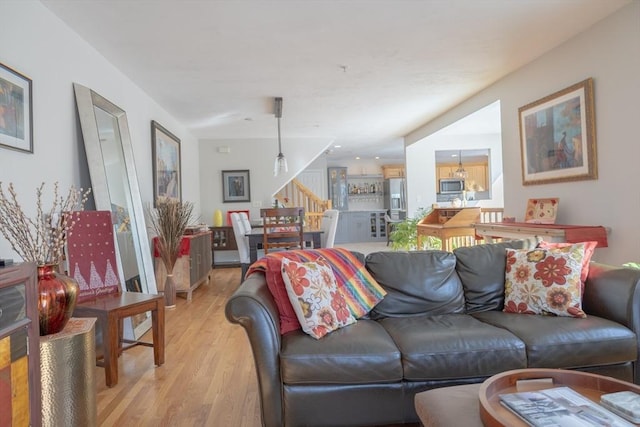 living area featuring stairway and light wood-style flooring