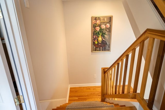 stairs featuring wood finished floors and baseboards