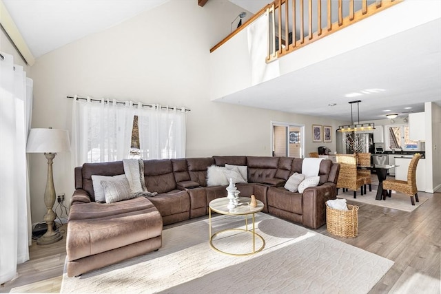 living room featuring light wood-type flooring and high vaulted ceiling