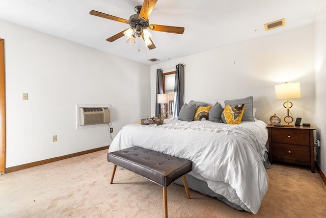 bedroom featuring visible vents, a wall unit AC, light carpet, and baseboards