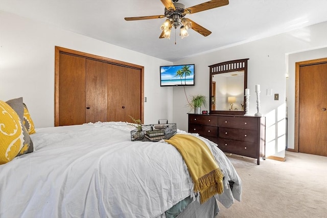 carpeted bedroom with ceiling fan and a closet