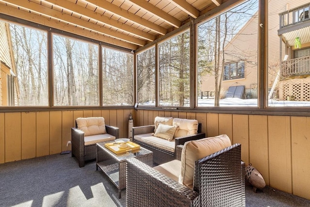 sunroom / solarium featuring beamed ceiling