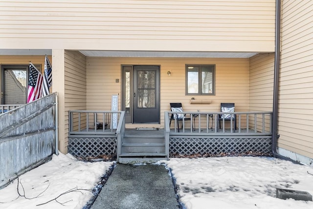 snow covered property entrance featuring a porch