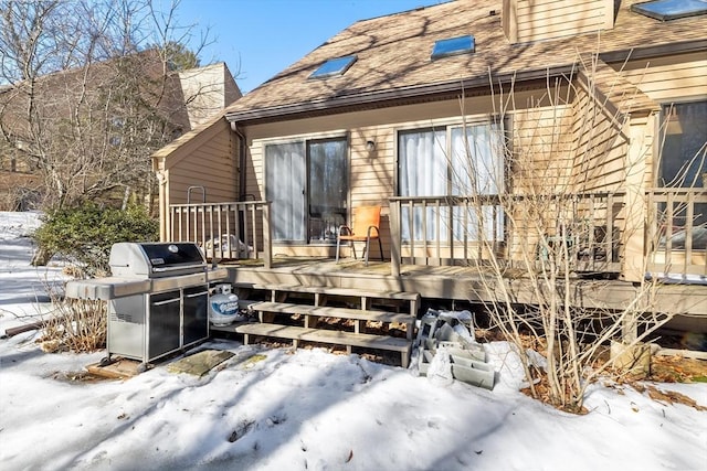 snow covered rear of property with roof with shingles and a chimney