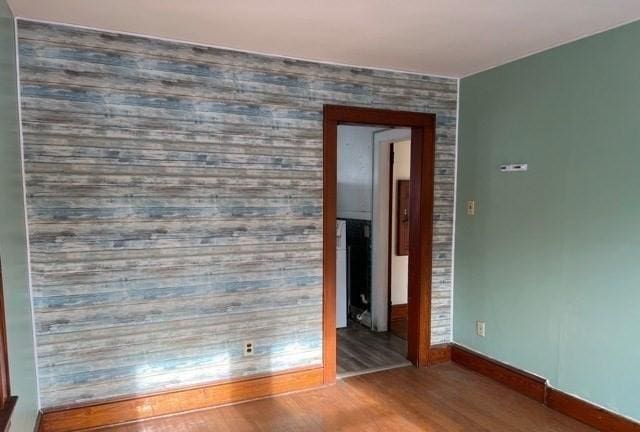 unfurnished room with baseboards and wood finished floors