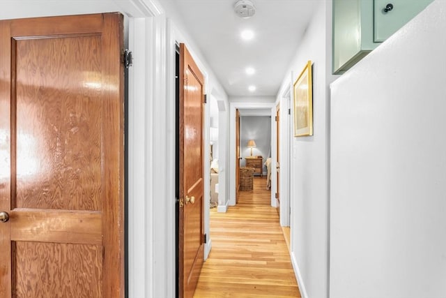 hall featuring recessed lighting, baseboards, and light wood-type flooring