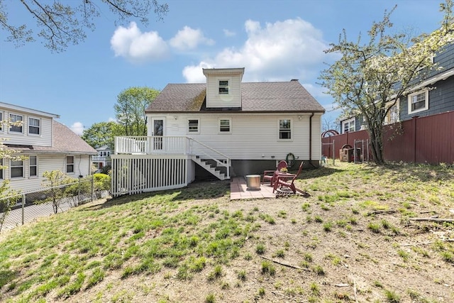 back of property with a deck, a patio, a fenced backyard, a yard, and stairway