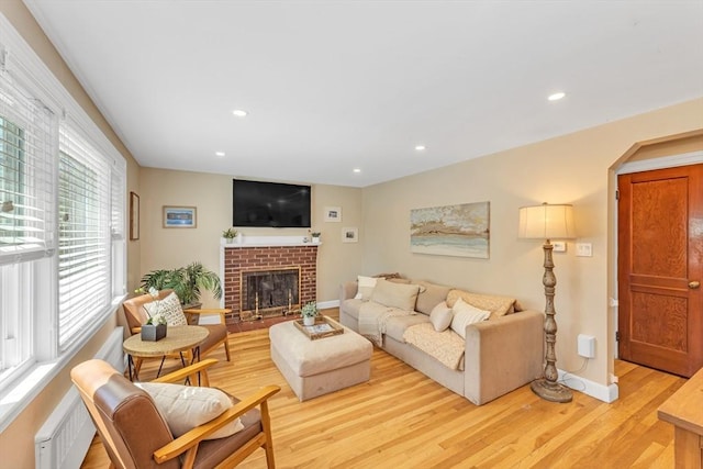 living room with recessed lighting, baseboards, light wood-style flooring, and a fireplace