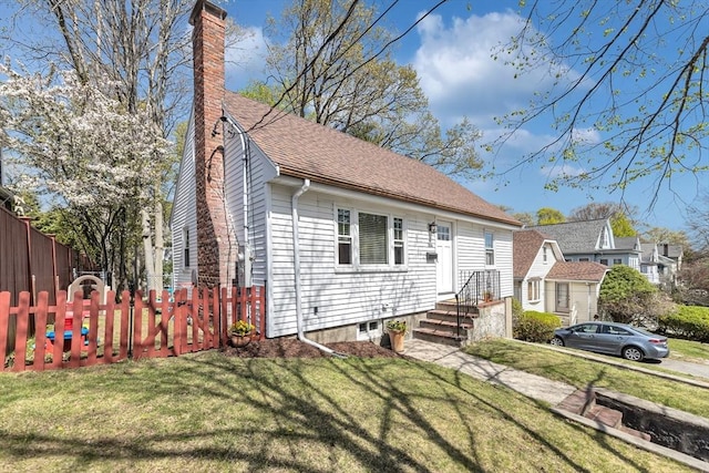 bungalow with fence, a chimney, and a front lawn
