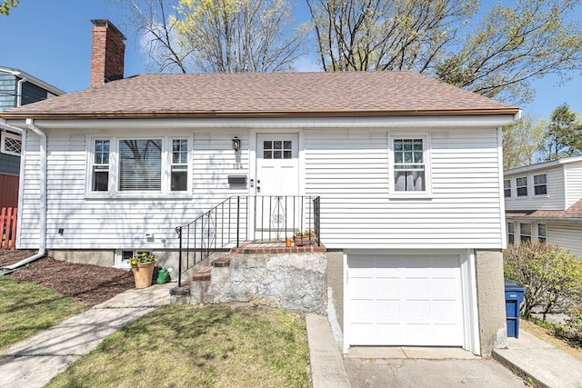 ranch-style house with an attached garage, driveway, a chimney, and roof with shingles