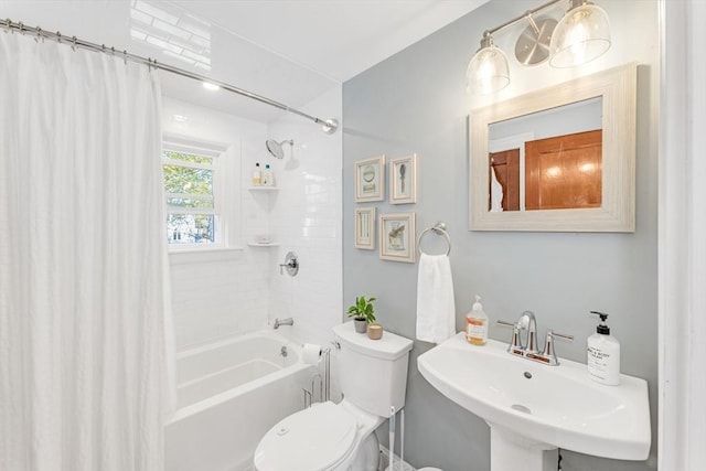 full bathroom featuring a sink, shower / bath combo with shower curtain, and toilet