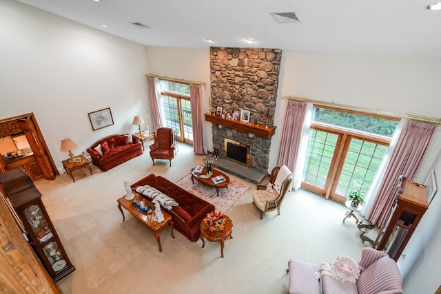 living room with a stone fireplace, high vaulted ceiling, and a healthy amount of sunlight