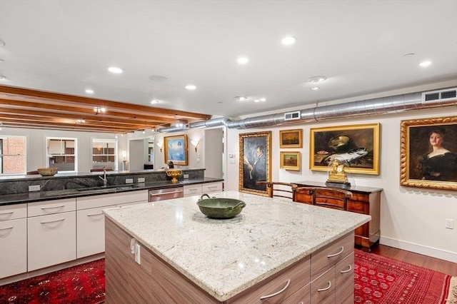 kitchen with sink, dishwasher, a center island, light stone countertops, and white cabinets