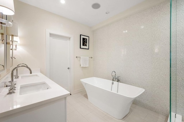 bathroom featuring tile patterned floors, a tub to relax in, and vanity