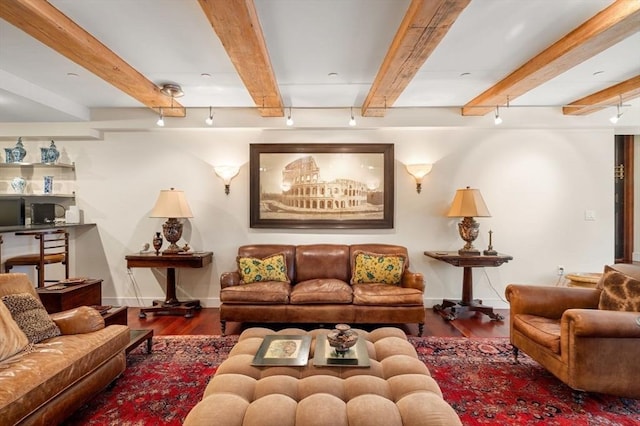 living room featuring beamed ceiling, rail lighting, and dark hardwood / wood-style flooring