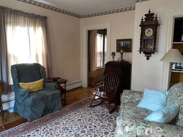 living area with baseboard heating and hardwood / wood-style flooring