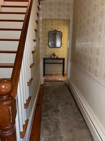 corridor with baseboard heating and dark hardwood / wood-style flooring