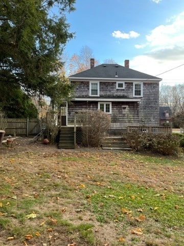 back of house featuring a lawn and a deck