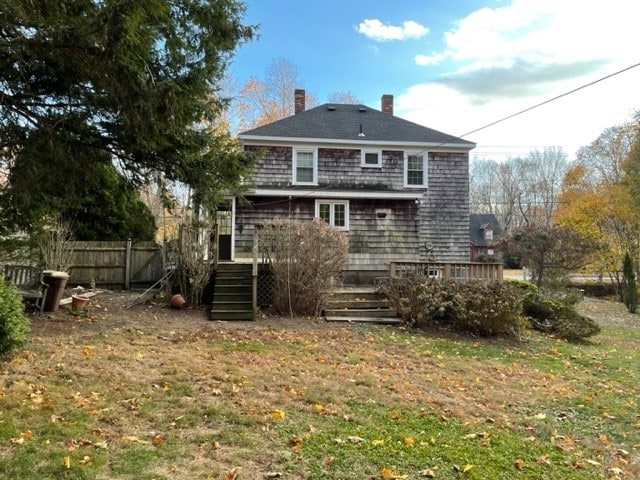 back of property featuring a lawn and a wooden deck