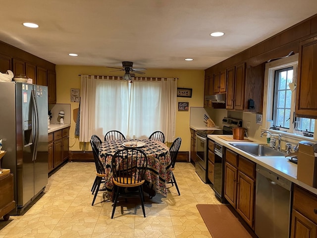 kitchen with appliances with stainless steel finishes, sink, and ceiling fan