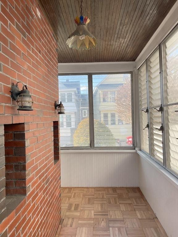 unfurnished sunroom featuring plenty of natural light and wood ceiling