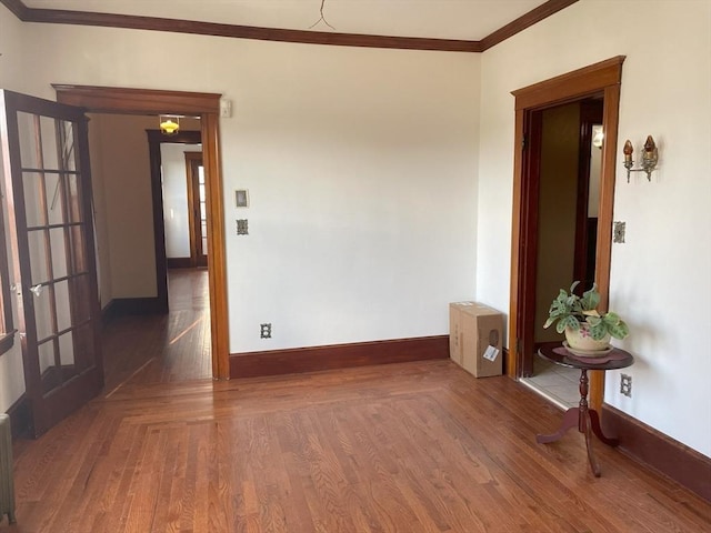 spare room featuring ornamental molding and dark wood-type flooring