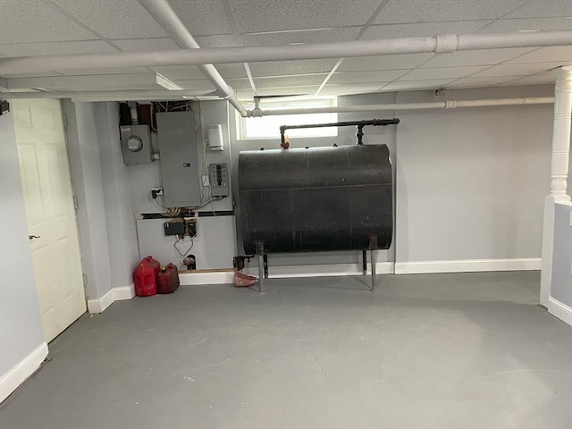 basement with electric panel and a drop ceiling