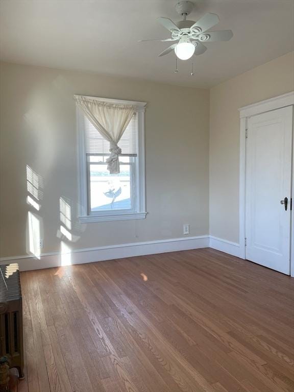 spare room with hardwood / wood-style floors and ceiling fan