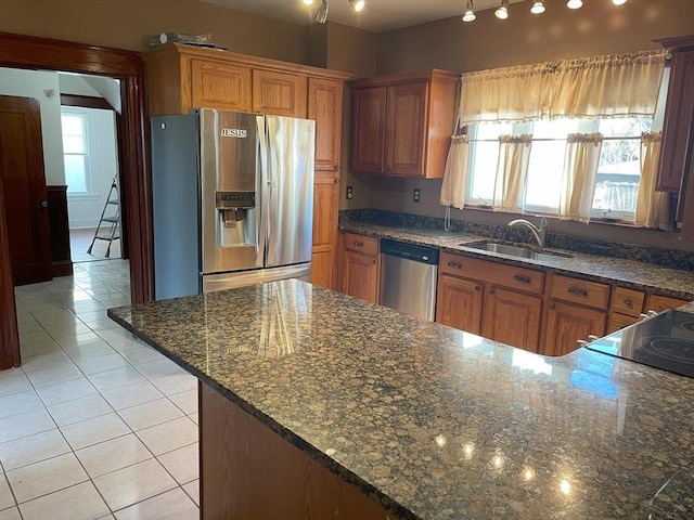 kitchen featuring light tile patterned flooring, stainless steel appliances, plenty of natural light, and sink