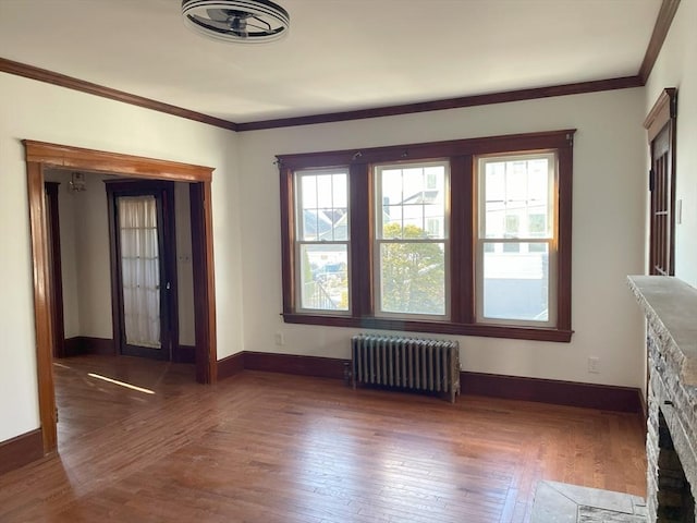 unfurnished living room featuring crown molding, radiator heating unit, and dark wood-type flooring