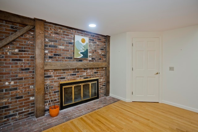 unfurnished living room with a brick fireplace and hardwood / wood-style floors