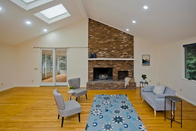 living room featuring a healthy amount of sunlight, a skylight, and light hardwood / wood-style flooring