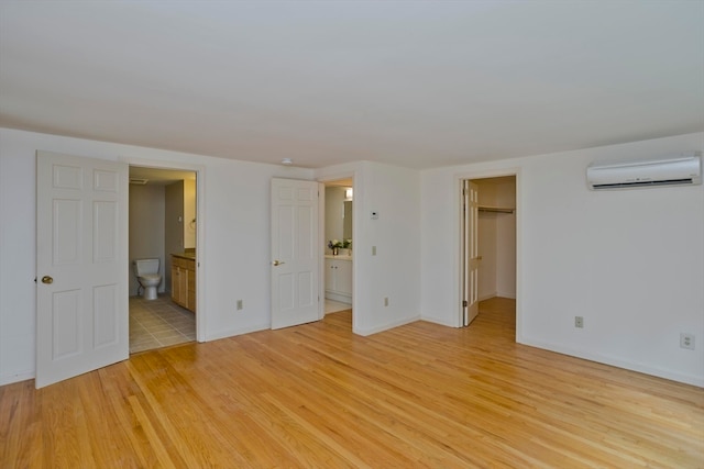 spare room with an AC wall unit and light wood-type flooring