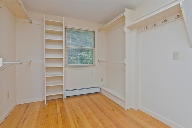 spacious closet with hardwood / wood-style floors and a baseboard radiator