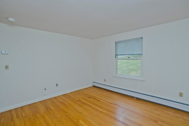 empty room with baseboard heating and light wood-type flooring