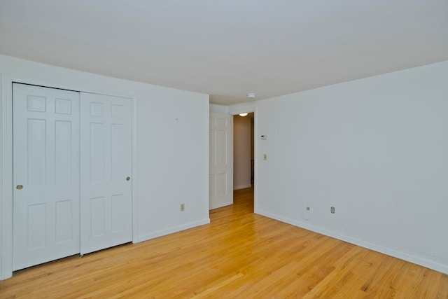 unfurnished bedroom featuring light hardwood / wood-style floors and a closet