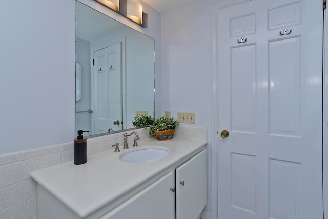 bathroom with vanity and tile walls