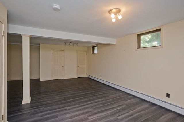 basement with a baseboard heating unit and dark hardwood / wood-style floors