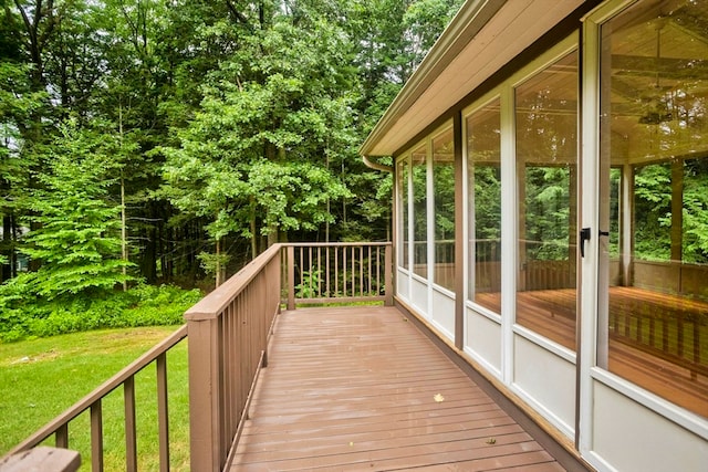 wooden deck featuring a yard and a sunroom