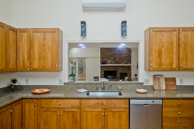 kitchen with dishwasher, a wall mounted AC, dark stone countertops, sink, and a fireplace