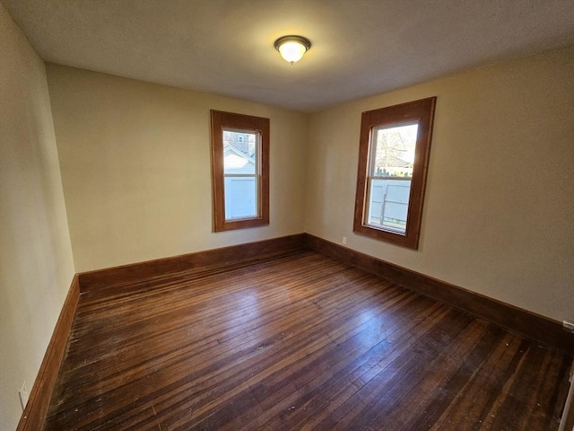 unfurnished room with dark hardwood / wood-style flooring