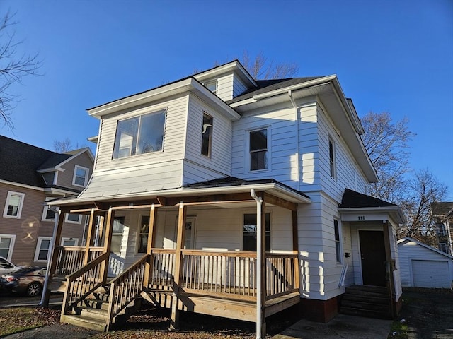 view of front of house featuring an outbuilding, covered porch, and a garage