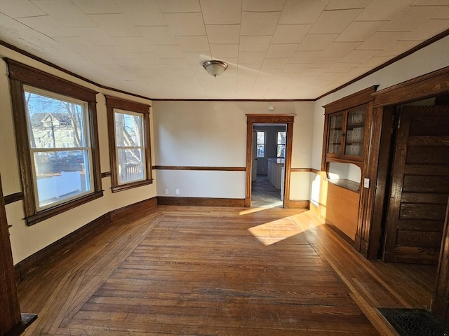 unfurnished dining area featuring crown molding and dark hardwood / wood-style flooring